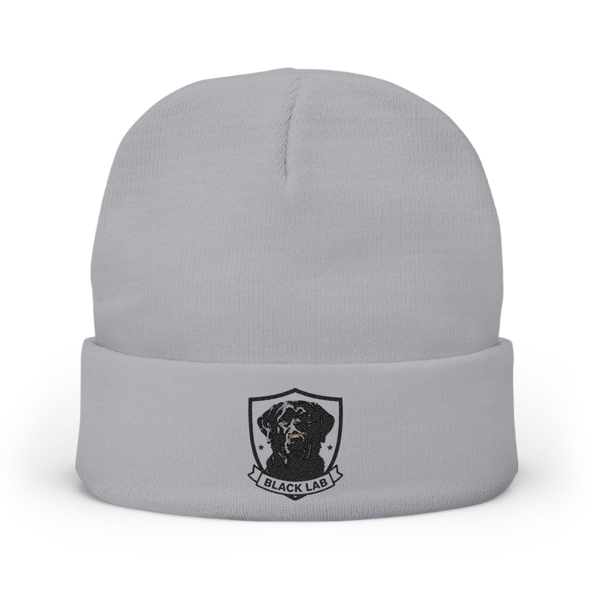 A light gray knit beanie hat with a folded cuff, featuring a black and white graphic of a dog inside a shield with the text 'BLACK LAB' below it.