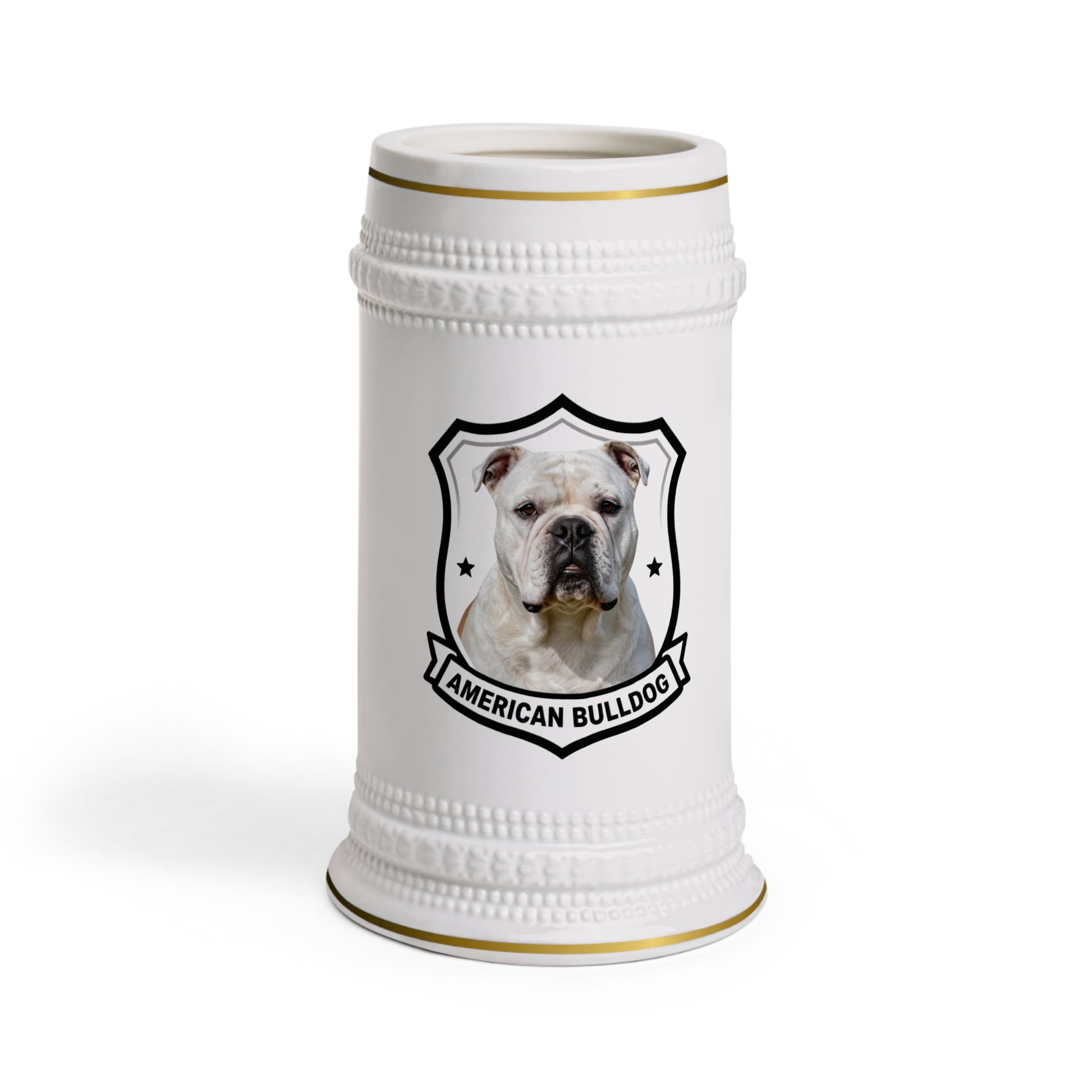 A white ceramic beer stein featuring a printed graphic of an American Bulldog inside a black shield outline, with gold trim accents at the rim and base.