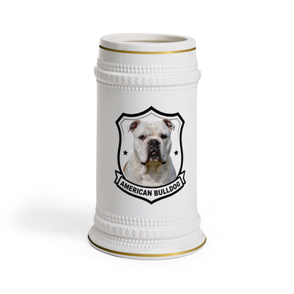 A white ceramic beer stein featuring a printed graphic of an American Bulldog inside a black shield outline, with gold trim accents at the rim and base.