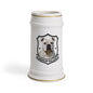 A white ceramic beer stein featuring a printed graphic of an American Bulldog inside a black shield outline, with gold trim accents at the rim and base.