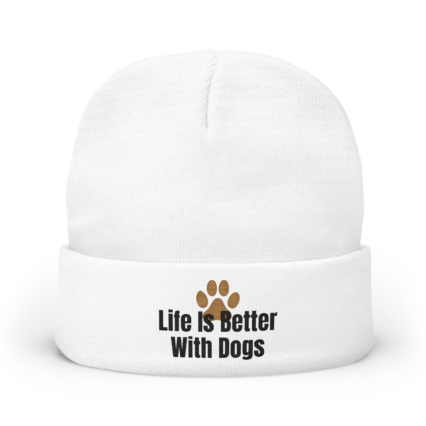 A white knit beanie hat with a folded cuff, featuring the text 'Life Is Better With Dogs' in black next to a brown paw print graphic.