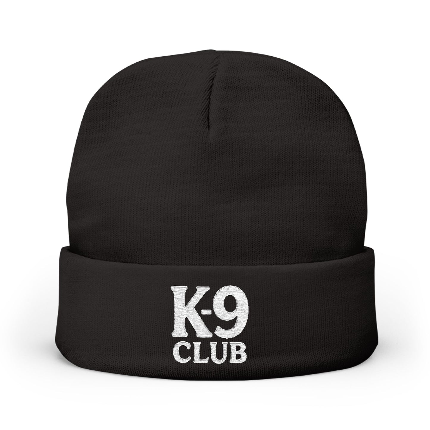 A black knit beanie hat with a folded cuff, featuring the words 'K-9 CLUB' embroidered in white on the front, set against a plain white background.