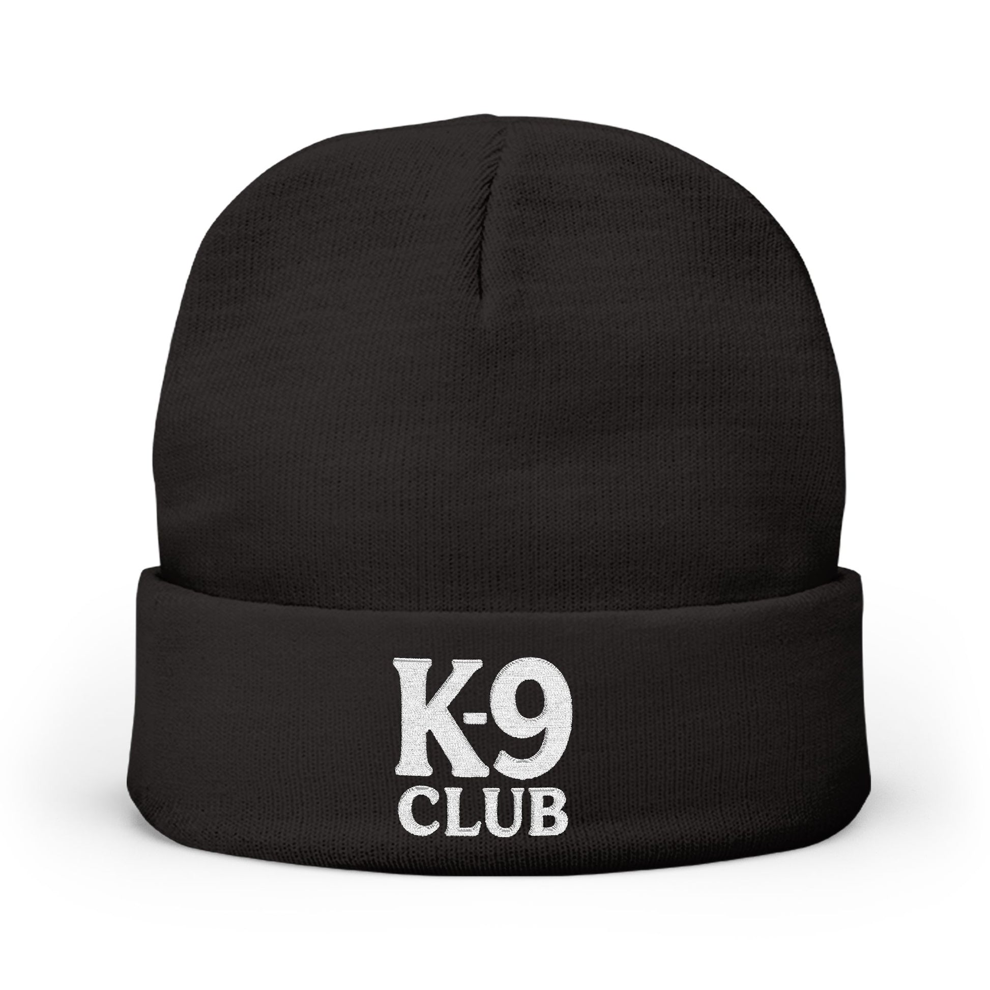 A black knit beanie hat with a folded cuff, featuring the words 'K-9 CLUB' embroidered in white on the front, set against a plain white background.