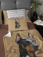 a tan bedding set with a large printed Doberman portrait on the blanket and matching pillow. Both items sold separately