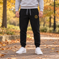  black jogger sweatpants with a small K9 Club gold crest logo on the left thigh