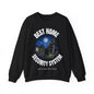 A black crewneck sweatshirt featuring a graphic print of a dog standing in front of a house under a full moon, with the text 'BEST HOME SECURITY SYSTEM' arched above and below the illustration. Small text at the bottom reads 'SANSY CAHON COLLECTION'.
