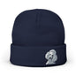 A navy blue knit beanie hat featuring a small embroidered white poodle on the front cuff