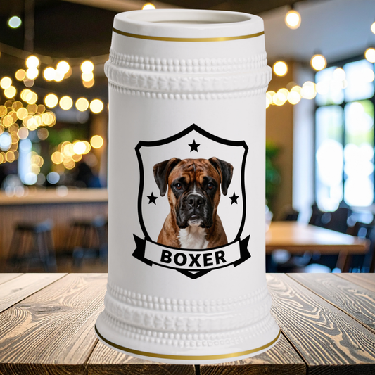 A white ceramic beer stein with a gold rim, featuring a custom portrait of a Boxer dog inside a black shield with the word 'BOXER' on a banner