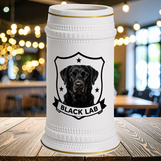 A white ceramic beer stein with gold trim and a portrait of a Labrador Retriever inside a shield with the text BLACK LABRADOR