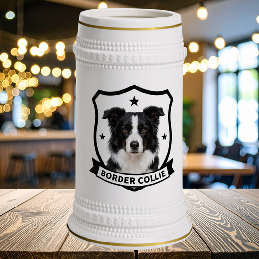 A white ceramic beer stein with gold trim  featuring a black shield emblem with a black-and-white Border Collie portrait and the words BORDER COLLIE