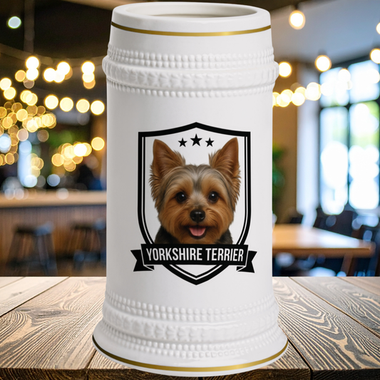 A white ceramic beer stein featuring a portrait of a Yorkshire Terrier inside a black shield with the text 'YORKSHIRE TERRIER' and three stars. The stein has gold trim at the rim and base 